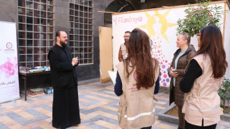 Arkkimandriitta Meletius Antiokian patriarkaatissa keskustelemassa avusustyöntekijöiden kanssa