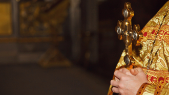 Ortodoksinen pappi pitelee ristiä