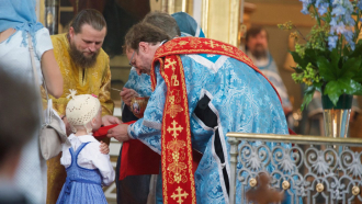 Tyttö osallistuu ehtoolliselle yhdessä äitinsä kanssa Uspenskin katedraalissa