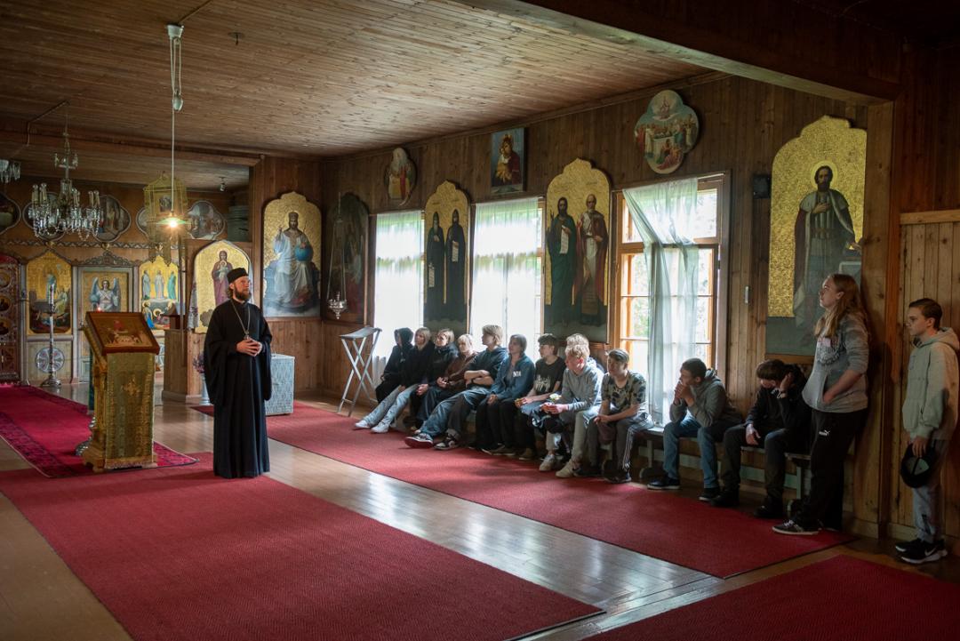 Valamon luostarin johtaja arkkimandriitta MIkael opastaa nuoria luostarin Vanhassa kirkossa