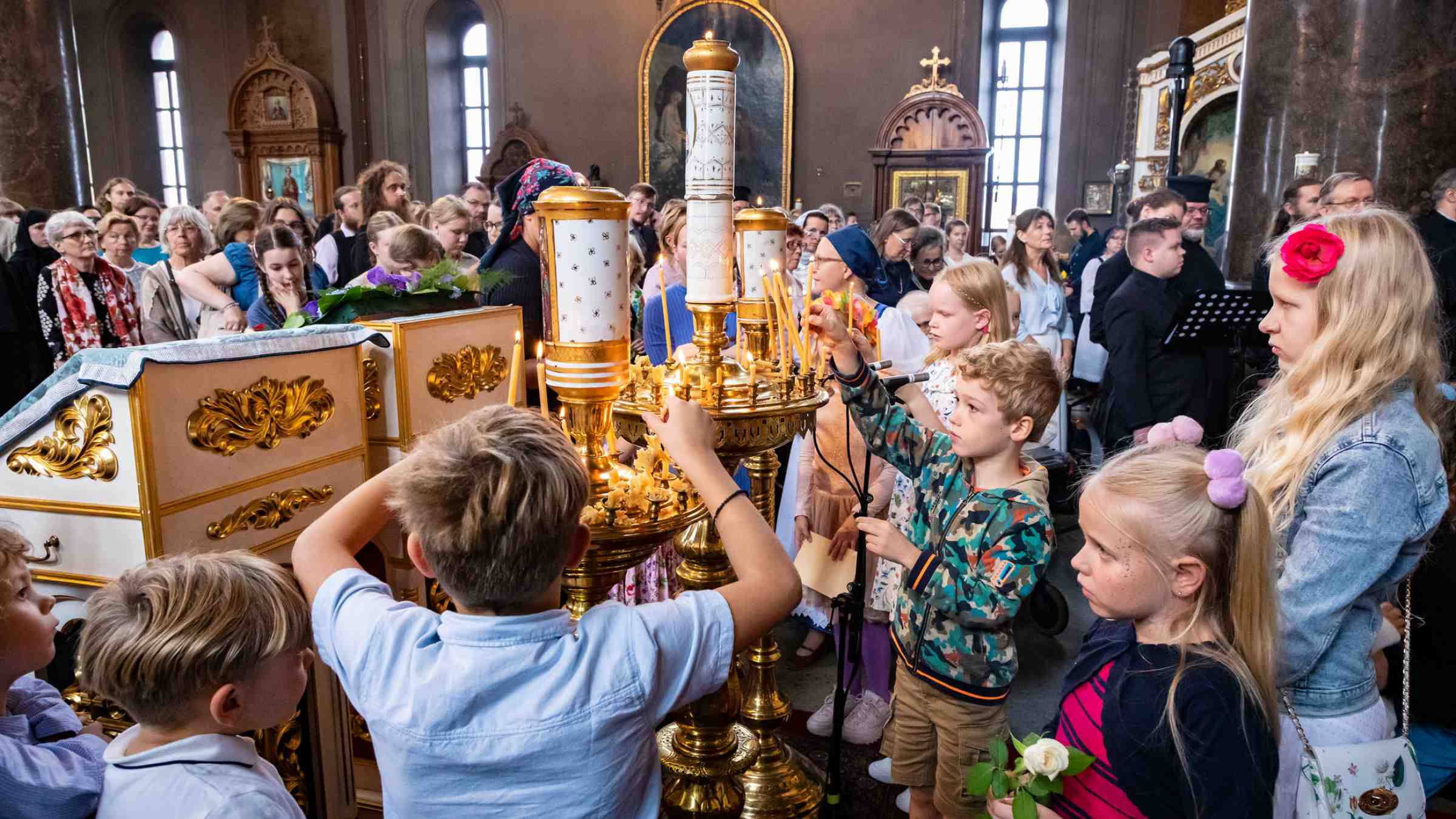 Jumalanpalveluksessa lapsia sammuttamassa tuohuksia Uspenskin katedraalissa