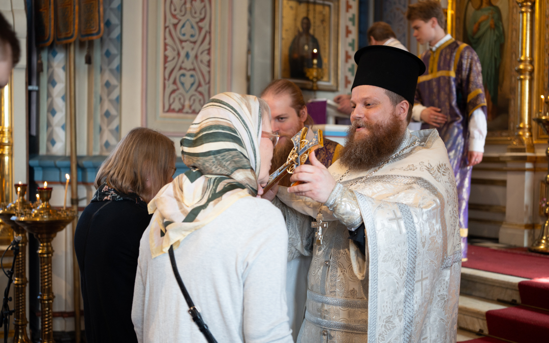 Isä Lassi Nuutinen siunaa ristillä kirkossa 2025 