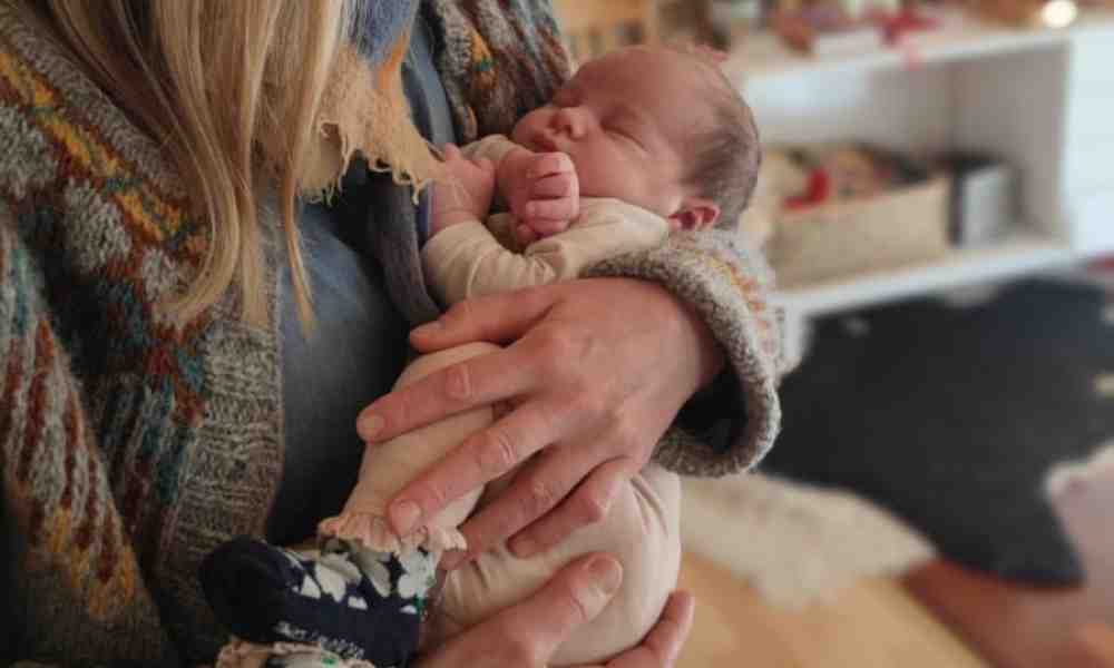 Doula Susanna Suutarla pitää sylissään vastasyntynyttä vauvaa