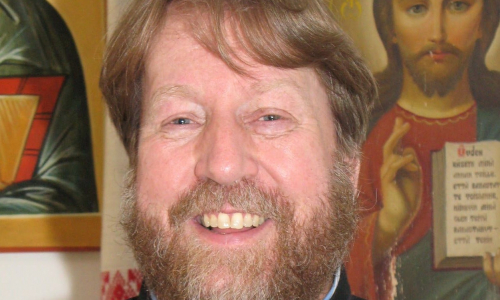 Isä Timo Mäkirinta Jyväskylän ortodoksisesta seurakunnasta lähikuvassa ikoneiden kanssa