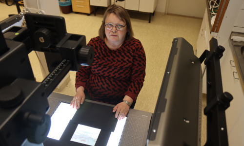 Marke Penttinen kuvaa arkkipiispa Hermanin lasinegatiiveja Suomen ortodoksisen kirkkomuseo Riisan tiloissa