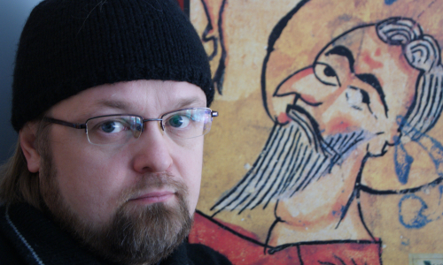 Pappismunkki Serafim Seppälä kuvattuna miestä esittävä maalaus taustallaan