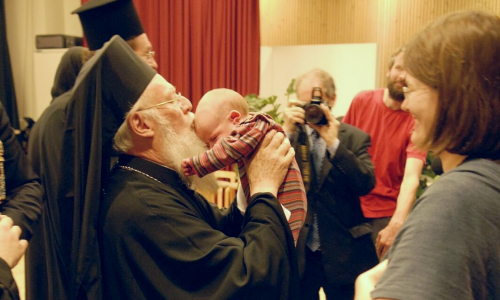 Patriarkka Bartolomeos suutelee vauvaa otsalle