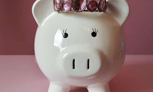 Säästöpossu katselee kolikkopinoja